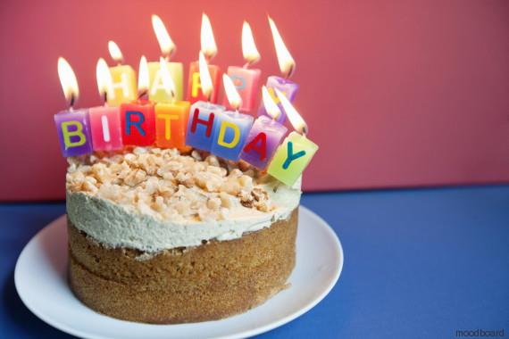Close-up of candles burning on birthday cake over colored background