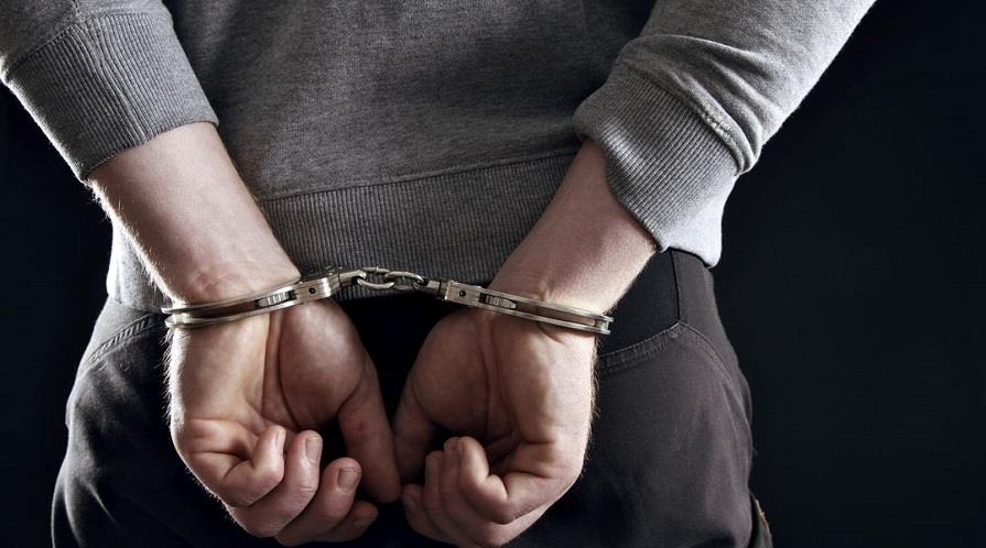 Outlaw's Hands Locked in Handcuffs