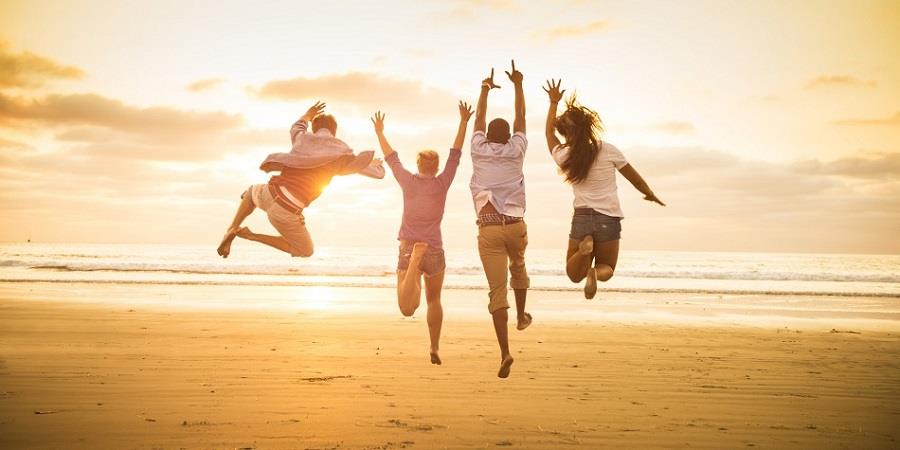 Young people jumping on Mission Beach, San Diego, California, USA