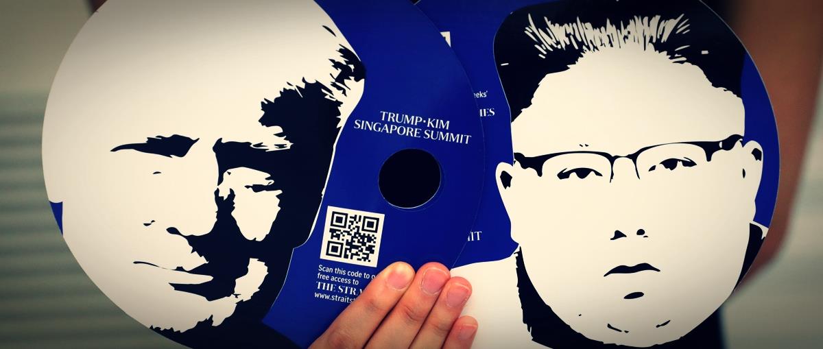 A worker of a media center for the summit between the U.S and North Korea shows fans featuring the images of U.S. President Donald Trump and North Korean leader Kim Jong Un,  which provided for journalists in a media kit at the media center in Singapore