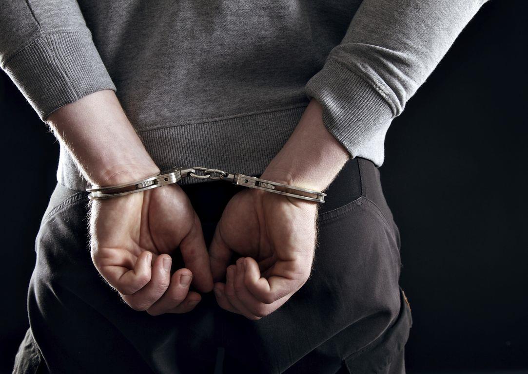 Outlaw's Hands Locked in Handcuffs