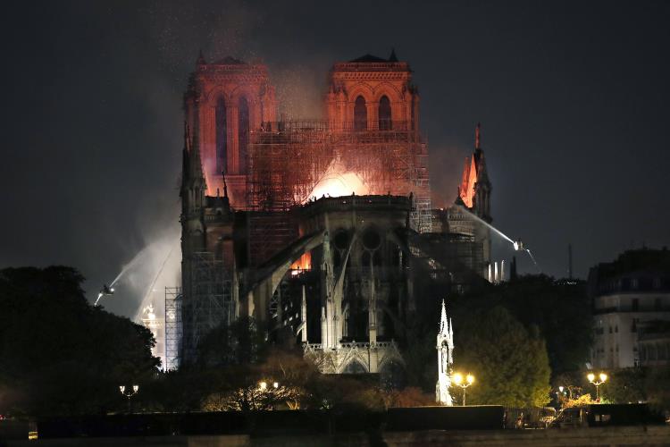 epa07508942 General view of the flames burning the roof of the Notre-Dame Cathedral in Paris, France, 15 April 2019. A fire started in the late afternoon in one of the most visited monuments of the French capital.  EPA/IAN LANGSDON