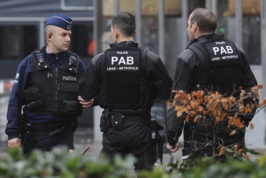 Police officers guard the street, following a grenade attack in the city center of Liege, Belgium, Tuesday, Dec. 13, 2011.   It is reported that an unidentified man threw up to four live hand grenades at a bus stop, killing the man and others, and wounding many other people in the crowded square. (AP Photo/Ermindo Armino)