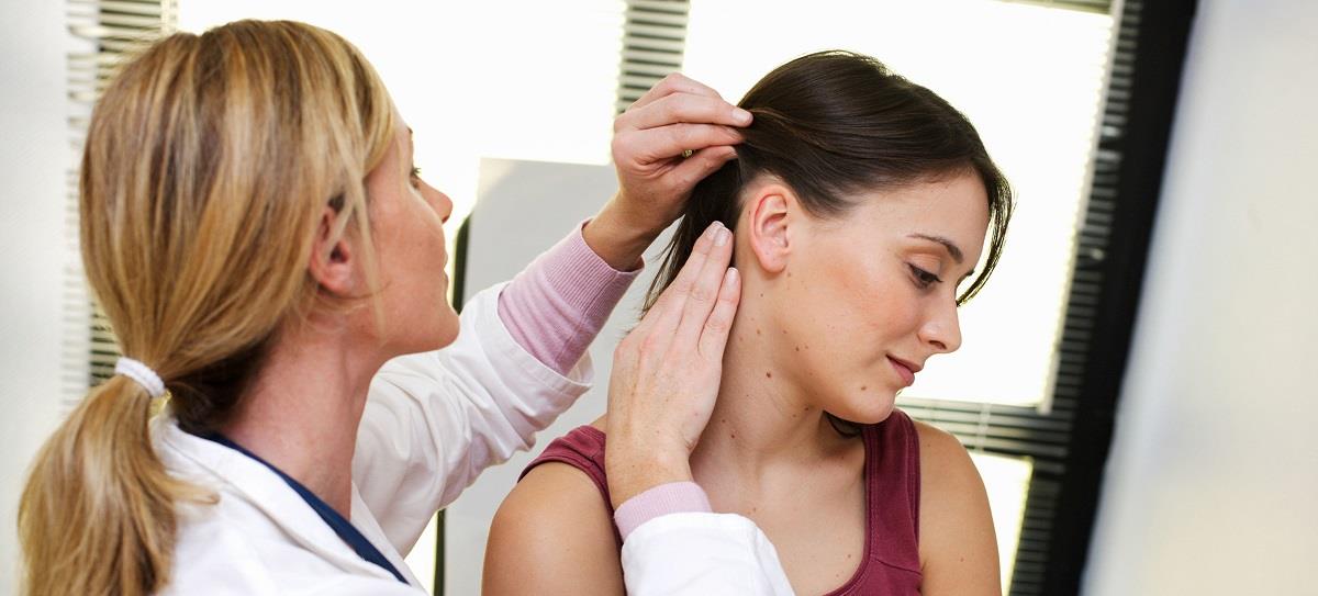 Doctor examining the scalp and skin of a patient.