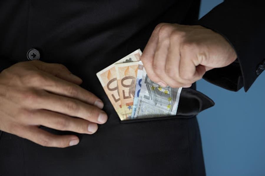 Businessman putting money in pocket