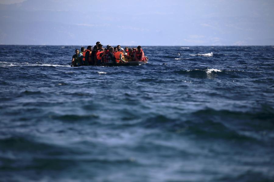 Syrian refugees on a dinghy approach, in rough seas, a beach on the island of Lesbos