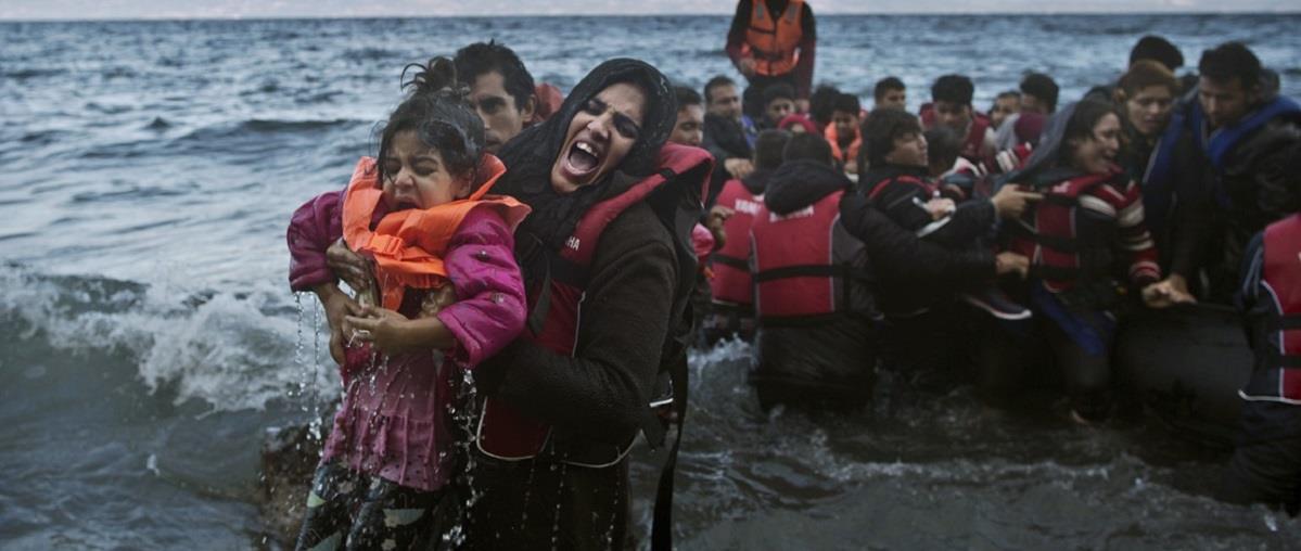 A refugee screams for help after she and her daughter fell in the water as they arrive along the northeastern Greek island of Lesbos,  Friday, Oct. 2 , 2015. The International Organization for Migration says a record number of people have crossed the Mediterranean into Europe this year. (AP Photo/Muhammed Muheisen)