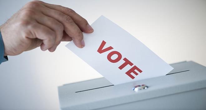 2010 --- Man putting vote card into box --- Image by © Tetra Images/Corbis
