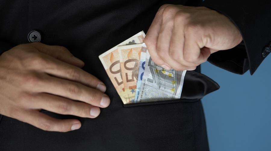 Businessman putting money in pocket