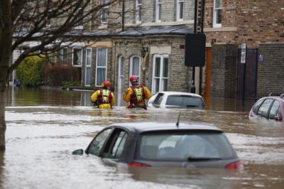 epa05082342 Rescue service workers work to evacuate residents from their flooded homes in York city centre, North Yorkshire, Britain, 28 December 2015. The nearby river Ouse burst its banks after heavy rainfall over Christmas and Boxing Day, causing widespread flooding across the north of Britain with many residents being evacuated by rescue services.  EPA/LINDSEY PARNABY