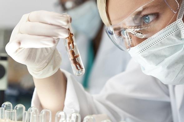 Female Scientific Research Team With Clear Solution In Laboratory