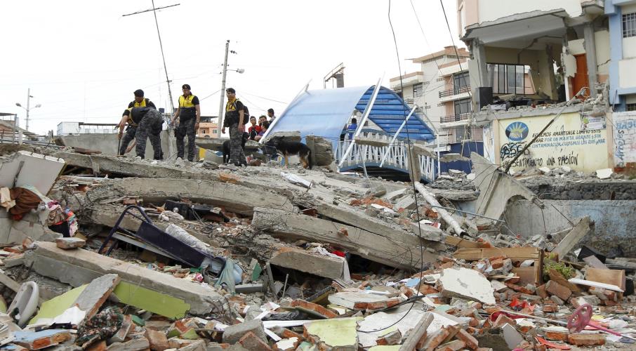 Police officers stand on debris after an earthquake struck off Ecuador's Pacific coast, at Tarqui neighborhood in Manta