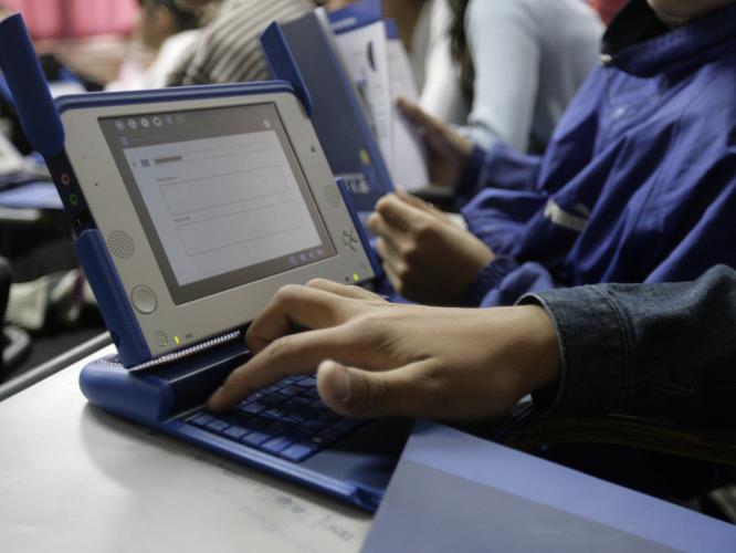 A second grade high school student checks his brand new XO low-cost laptop computer at a public high school in Casabo