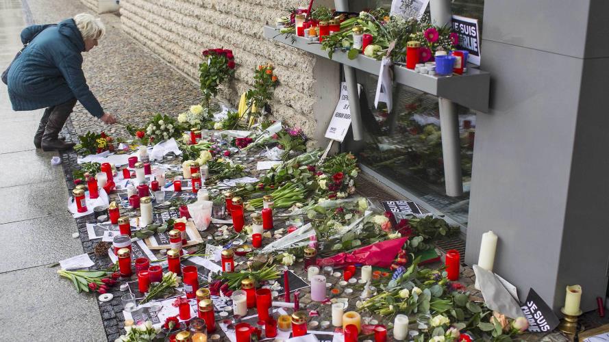 Woman places flowers of condolance at the French embassy at Pariser Platz in Berlin